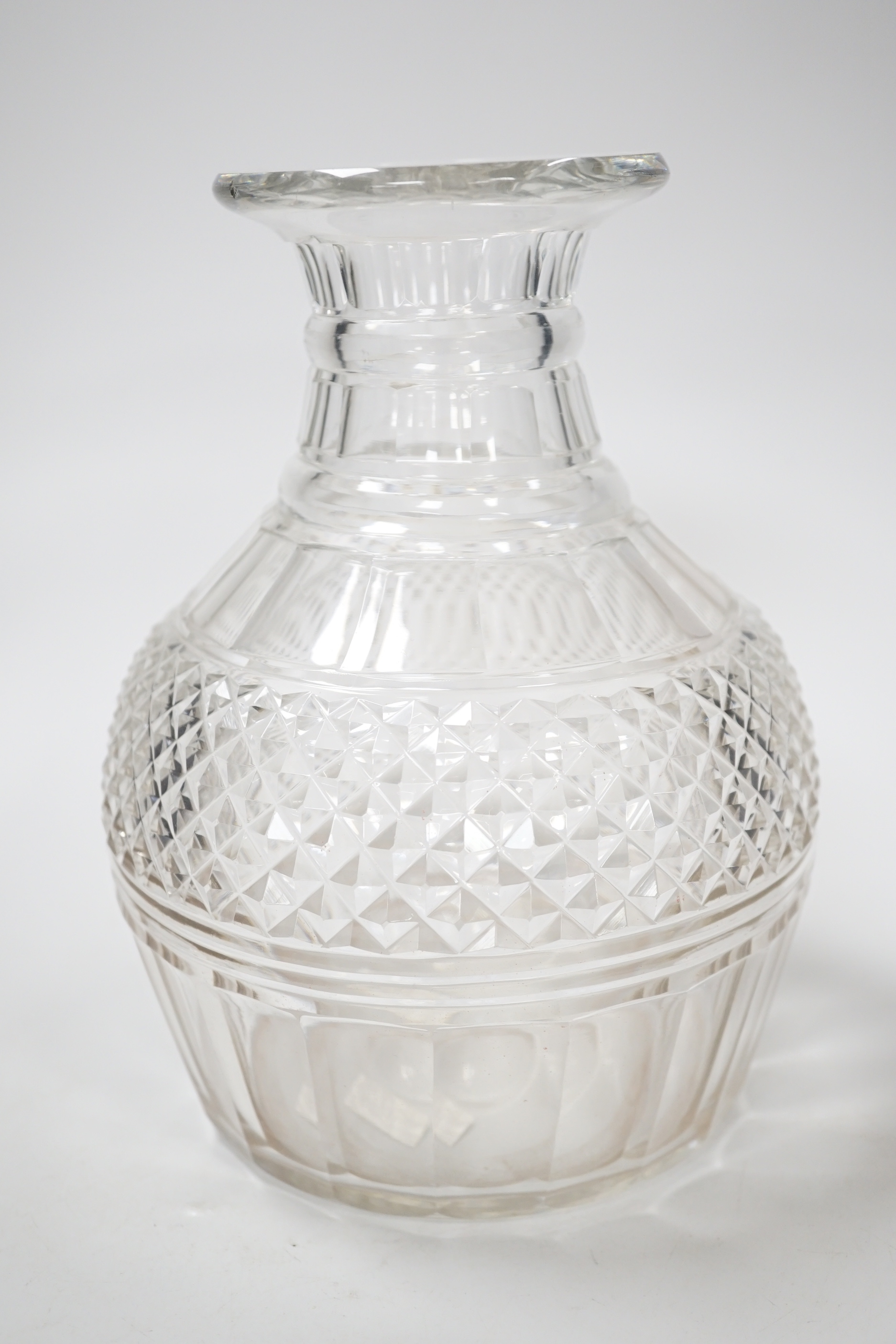 An English lead crystal Regency carafe, three rows of square cut facets alternate with two cut rings above a wide band of hobnails and further basal cut facets, ground and polished pontil, 20cm high